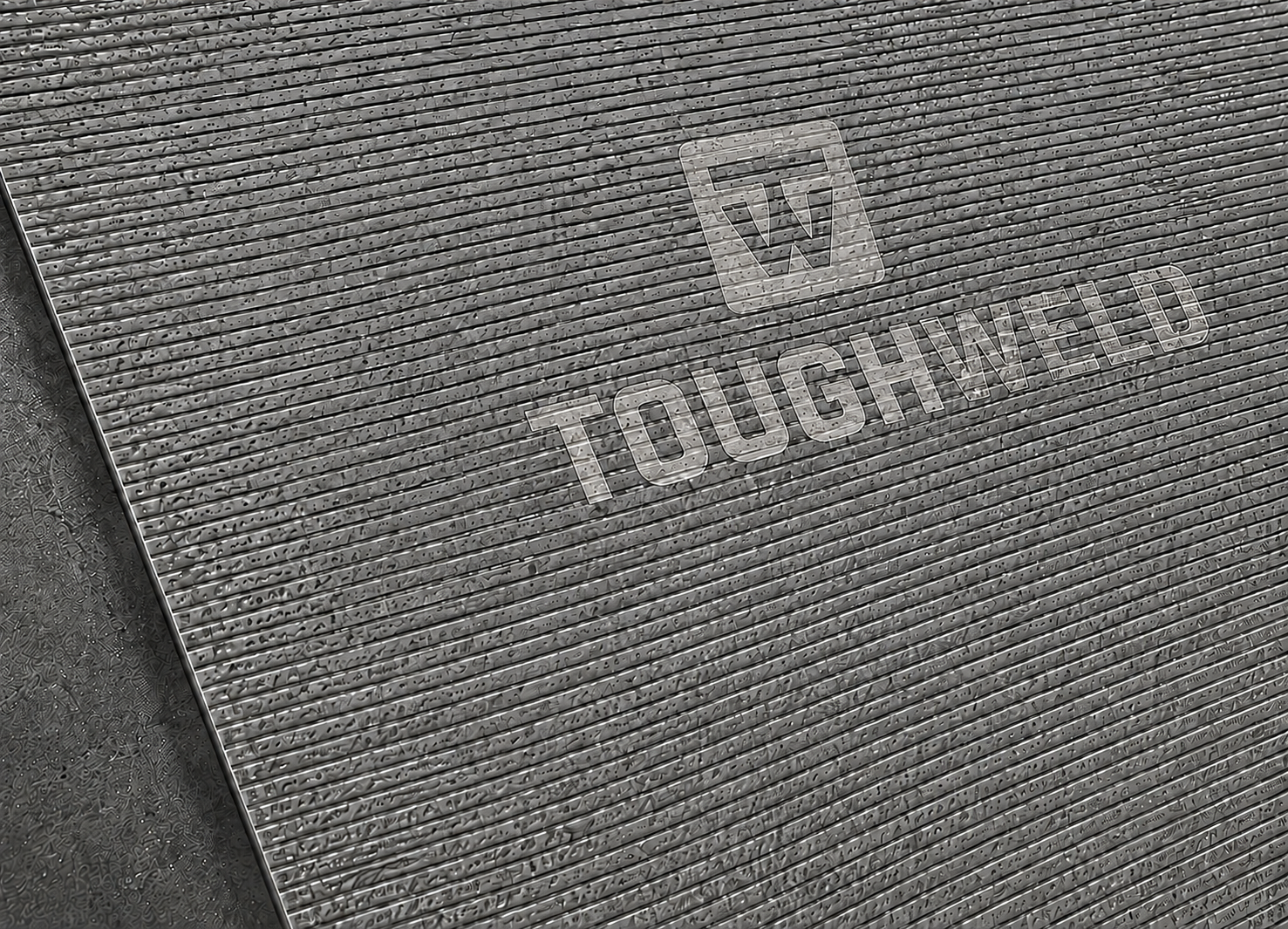 Close-up of TW100 chromium carbide overlay plate with laser-etched TW emblem above the Tough Weld wordmark